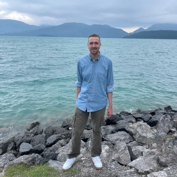 Tom Higginson sitting on rocks by the coast